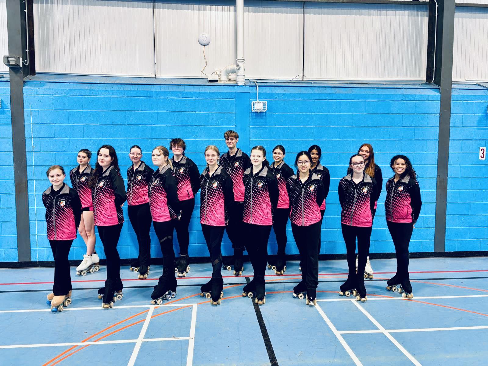 The TARSC squad lined up together in their pink-and-black club jackets at the rink.